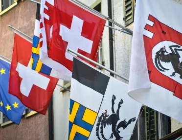 Swiss flags hanging on side of hotel. 