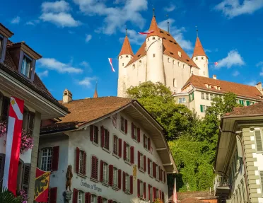 Ground-angle shot of Thun Castle, German architecture all around.