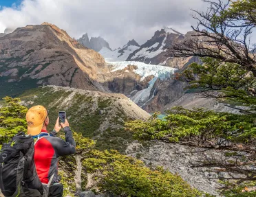 Guest taking photo of snowy mountain.