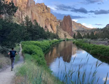 Guest running by small river in Smith Rock Park.