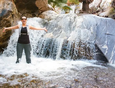 Woman with arms out in a waterfall