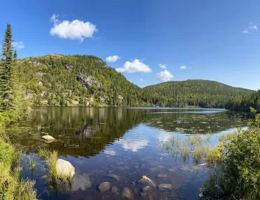 Wide shot of large lake, guest on left, looking out towards mountains.