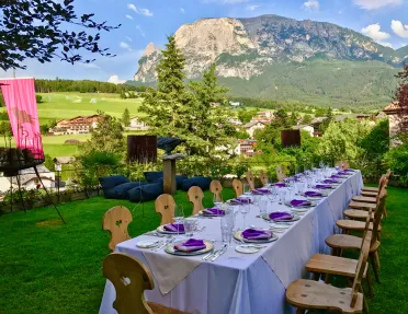 Long outdoor dining table set for a meal amid the Dolomites