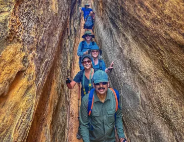 Guests lined up smiling in between rock walls