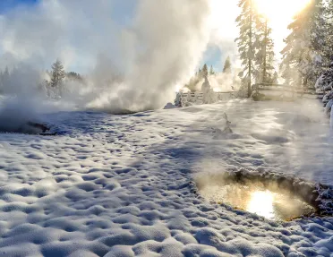 Snow covered landscape and hot springs with steam