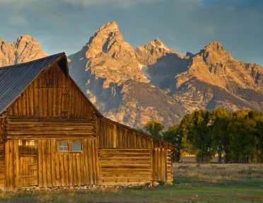 Wooden cabin with rocky mountains in background
