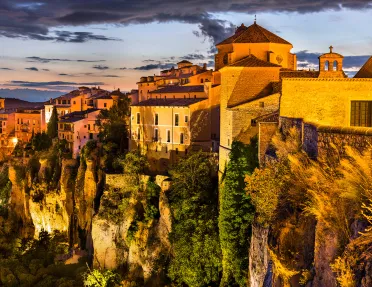 Sunset-lit cliffside, white houses above.