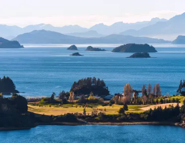 Small island with tall trees, with a vast ocean in the background