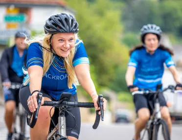 Women in Backroads branded biking gear riding on their bike