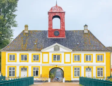 Yellow building with a red clocktower attached to the roof