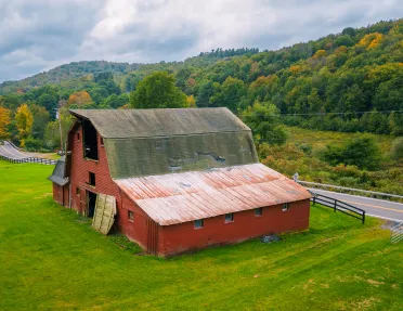 Red barn next to an empty road