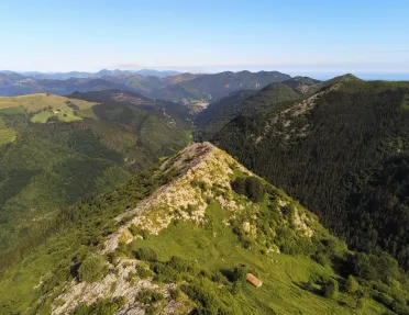 Grassy hill in the middle of an open valley of other hills