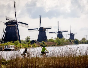Two bikers in front of windmills