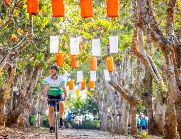 Man biking under colorful flags