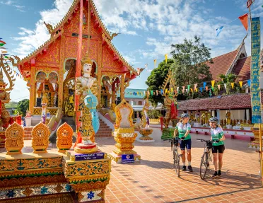 Two woman with bikes walking through a decorated town square