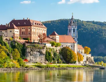 Large buildings on a small cliff overlooking a port