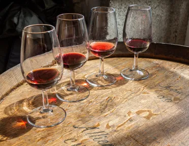 Four glasses of wine on top of a barrell
