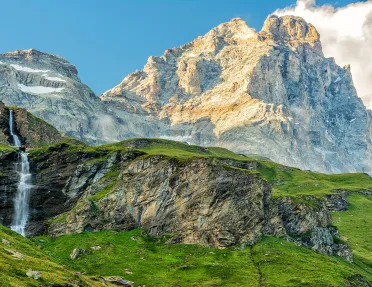 Grassy mountains in front of taller, foggy mountains