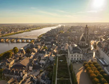 Sky view of a large, rustic town with a large bridge on the left