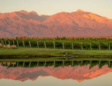 red mountain range reflected on water below it