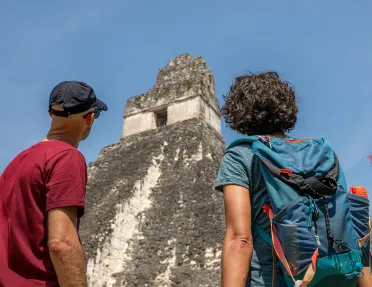 Two men looking up to an old pyramid