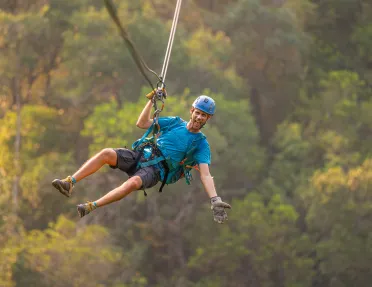 Man ziplining in the middle of the forest
