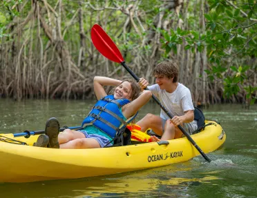 Two children kayaking in a river