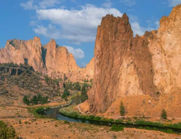 Large, orange canyons with a river on the ground level