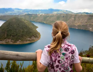 Child looking over a railing at an island