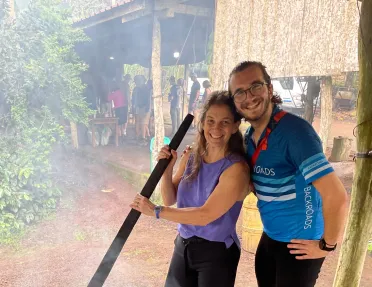 Two people stir a large pot