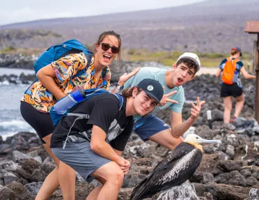 Three teenagers pose with a bird