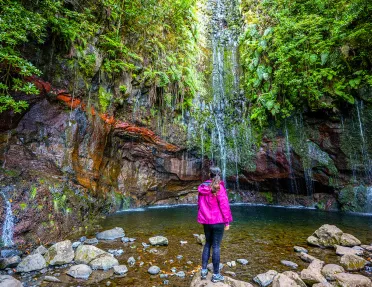 Woman standing on a rock looking at a lake 
