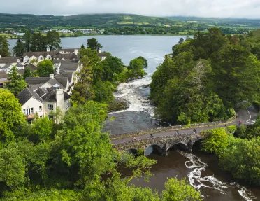 Stone bridge surrounded by trees with a river flowing underneath