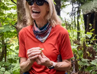 Woman laughing while holding plants in her hand