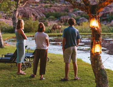 A group of people admire a grazing animal