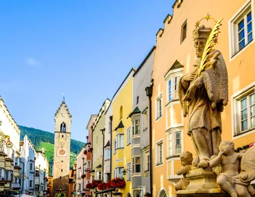 Spanish-style statue in a town center with a clocktower in the background