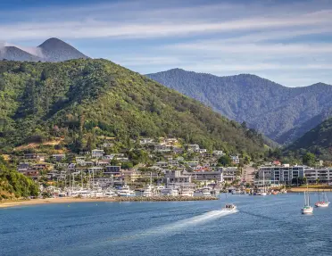 Small town next to a port with boats docked along the sand