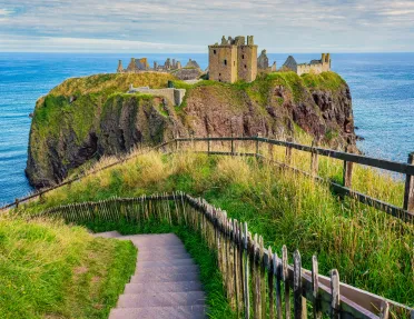 Rustic castle ruins on a cliff in the middle of an ocean