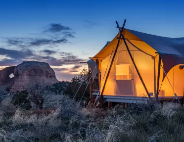 Glamping tent lit up in the desert
