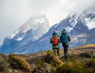 Two people walking through a valley filled with gravel