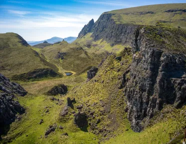 Open valley of grass with surrounding hills and cliffs