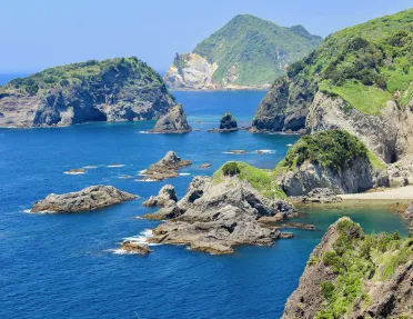 Ocean with large cliffs and boulders to the right