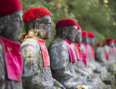 Row of stone statues, with knitted hats and handkerchiefs