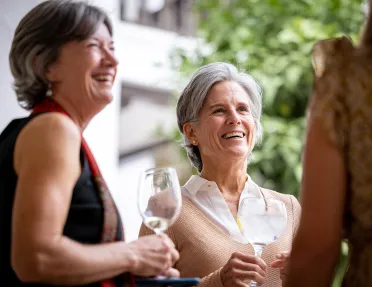 Group of women smiling while holding glasses of wine