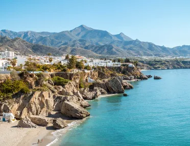 Wide shot view of a town on top of a cliff with the ocean to the right