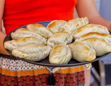 Person holding up a plate full of baked breads