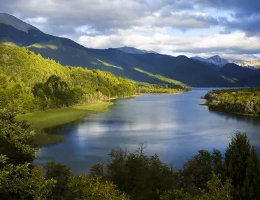 Large, open lake surrounded by tall trees and large hills