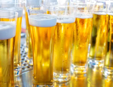 Multiple glasses of beer on a steel countertop