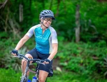 Woman wearing a Backroads jersey while riding a bike