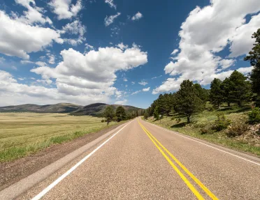 Long road in the middle of a large grass valley
